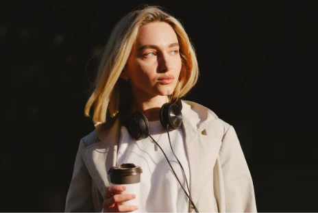 Woman with headset, coffee on hand