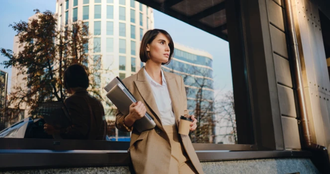 Woman with book on one hand and coffee on the other